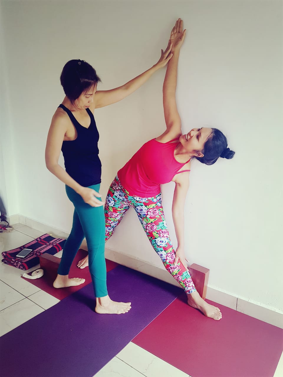 Our trainer Maki helping student to do yoga Pose